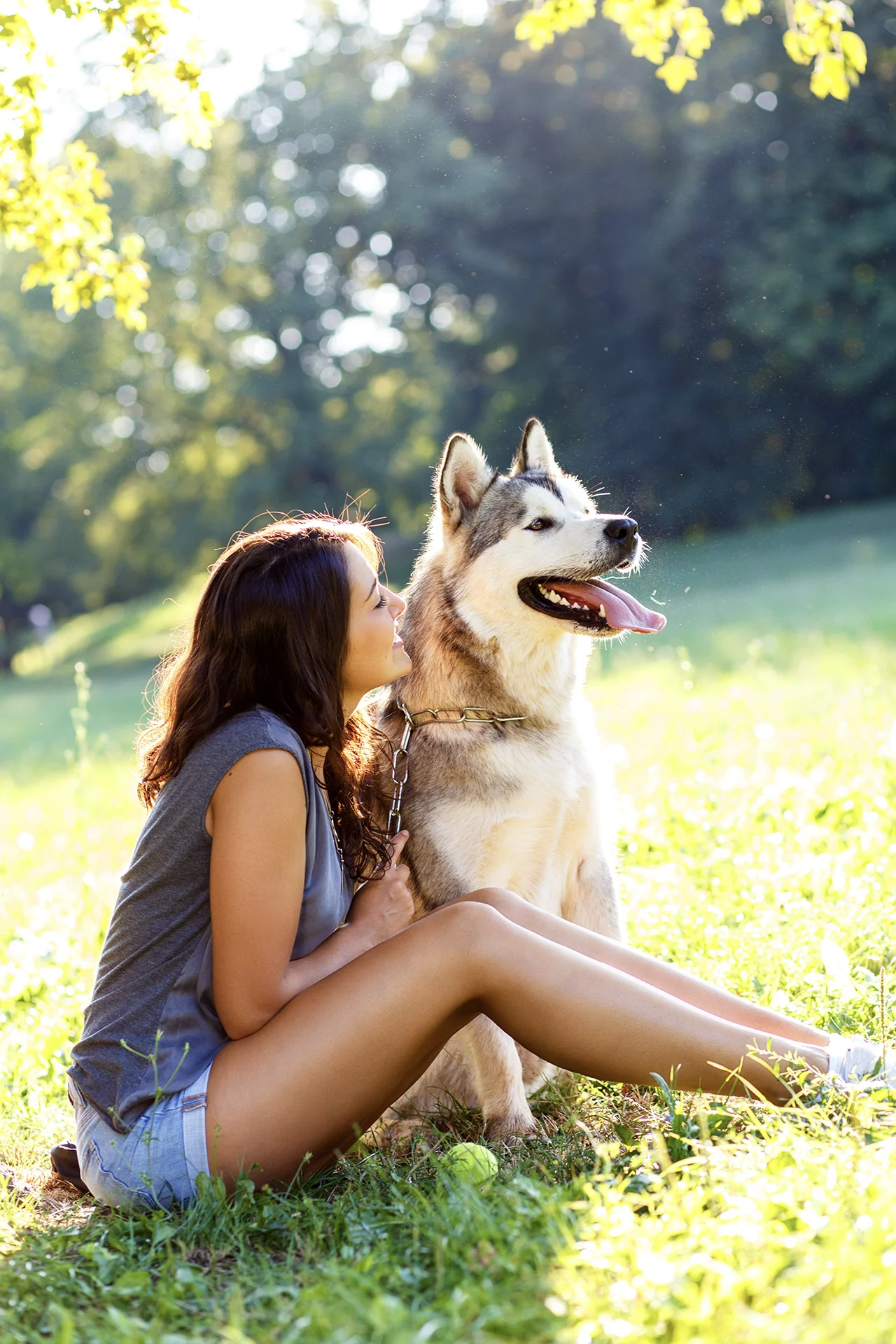 young woman playing with her dog in the park